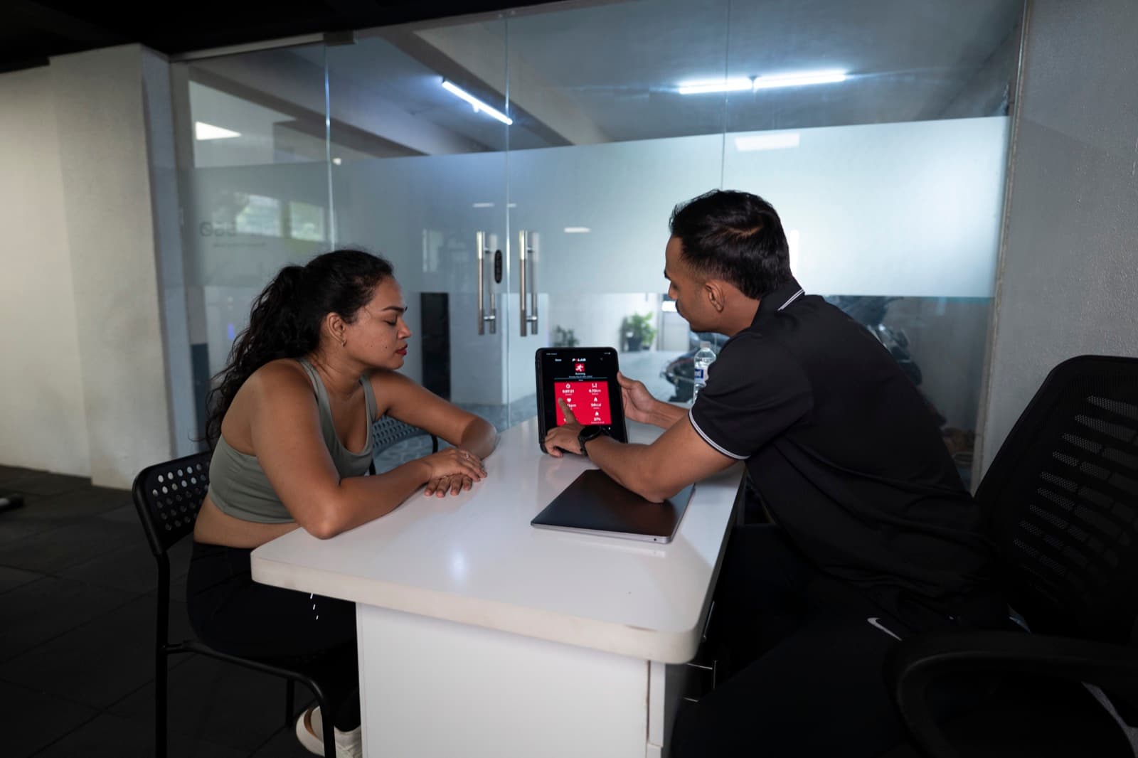 Lucky reviewing session data with a FIT360 client at the consultation desk