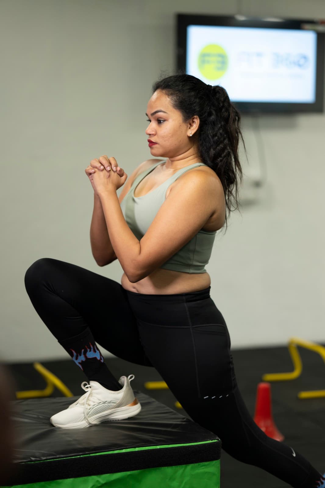 A FIT360 client performing a cossack squat on a plyo box