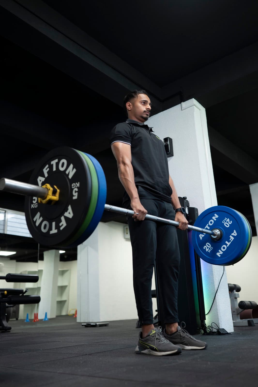 Coach Lucky setting up at the bottom of a barbell deadlift in the FIT360 studio