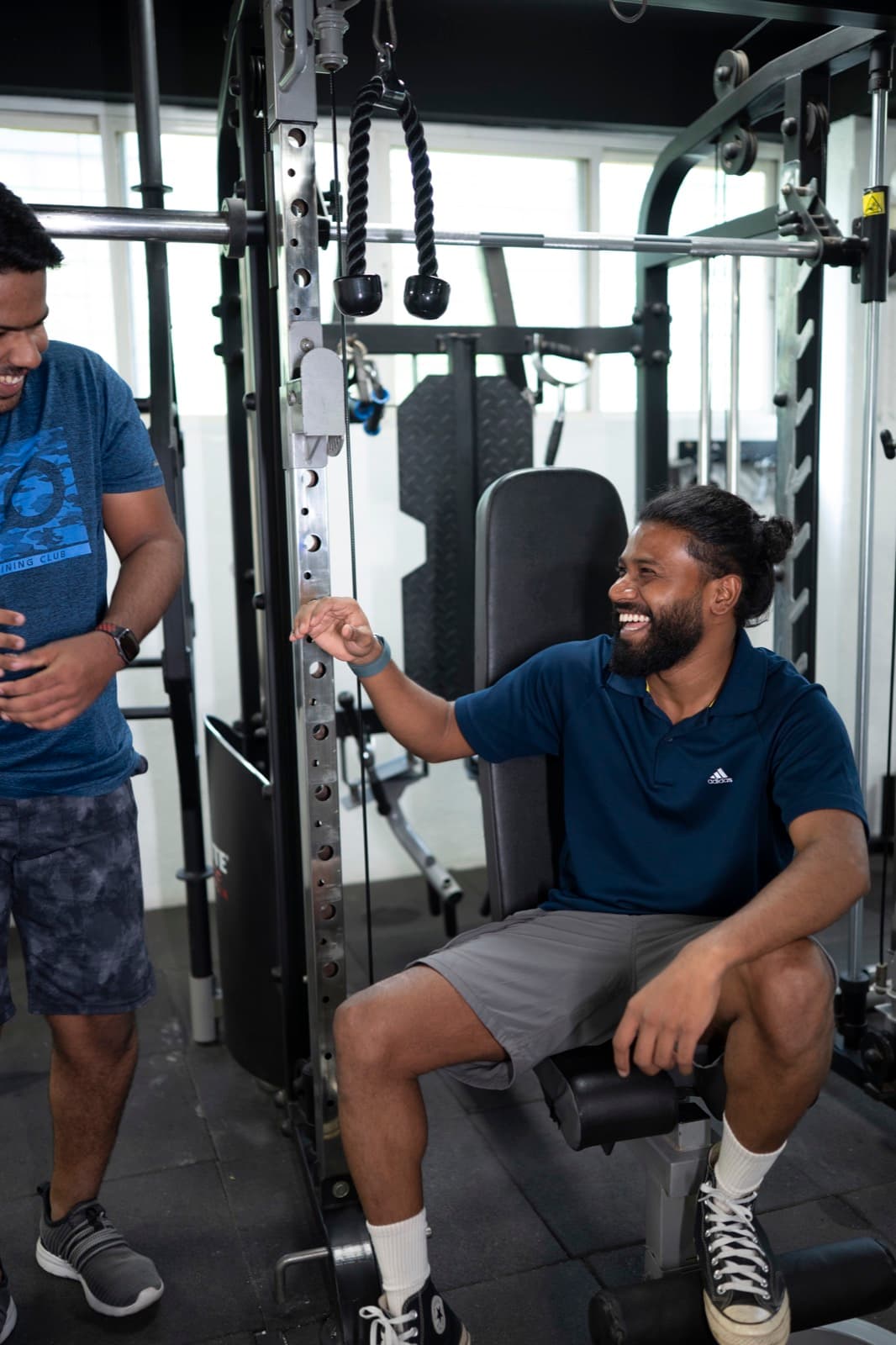 A FIT360 client laughing during a cable machine session